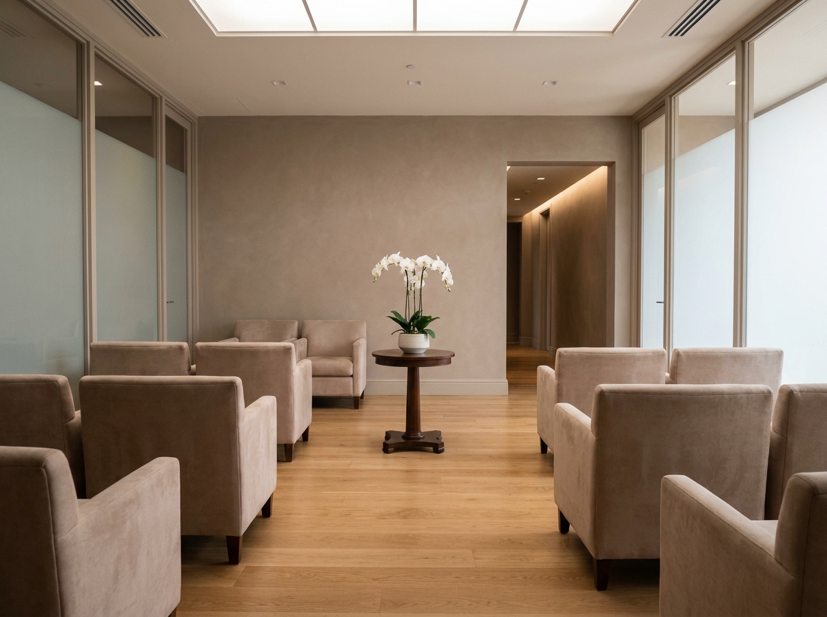 Salle d'accueil d'un funérarium moderne avec fauteuils beige, parquet en bois et orchidée blanche sur table, ambiance sobre et apaisante